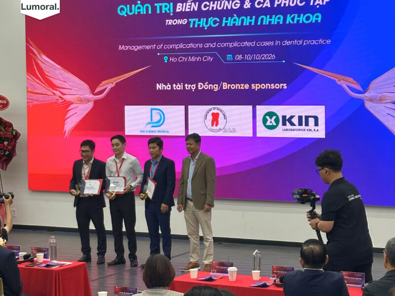 Đại diện gian hàng lên nhận thư cảm ơn và kỉ niệm chương tại hội nghị nha khoa VLU 2026